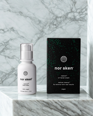 nor sken restore flaska och förpackning som står på en marmor hylla. 
